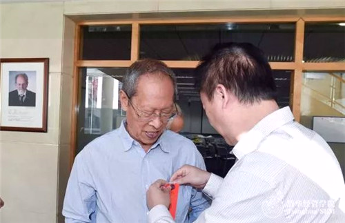 高建老師為老教師佩戴名簽.jpg